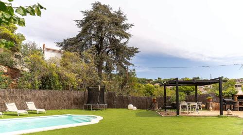 un patio trasero con piscina y cenador en Casa Can Roure, en Vilassar de Dalt