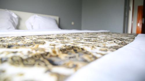 uma cama num quarto de hotel com um edredão em Cemara Guest House Syariah Kertajati em Babakan