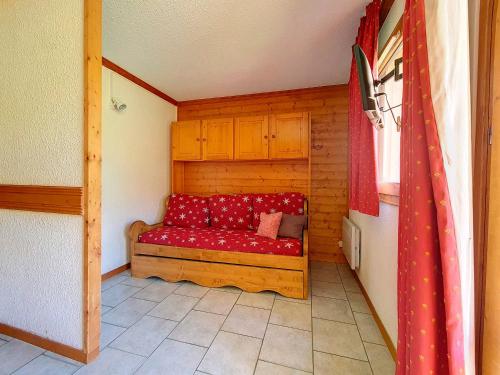 a red couch sitting in a small room at Appartement Les Menuires, 2 pièces, 4 personnes - FR-1-344-961 in Les Menuires