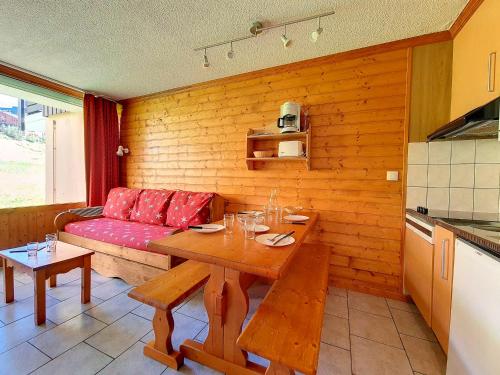 un salon avec une table et un canapé rouge dans l'établissement Appartement lumineux - Skis aux pieds - Terrasse plain pied - 4 pers - Preyerand, Les Belleville - FR-1-344-961, aux Menuires
