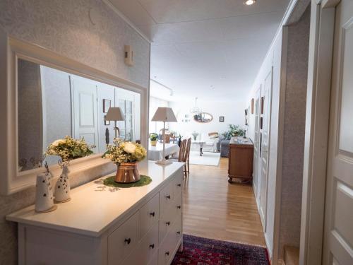 a hallway of a home with a dresser with flowers on it at Moonlight House Large holiday villa with sauna and free parking in Rovaniemi