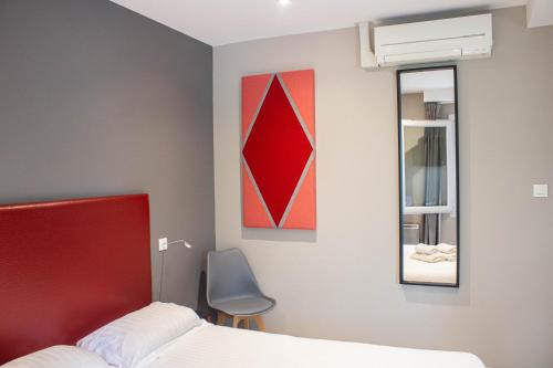 a bedroom with a red bed and a mirror at La Source in Porcieu-Amblagnieu