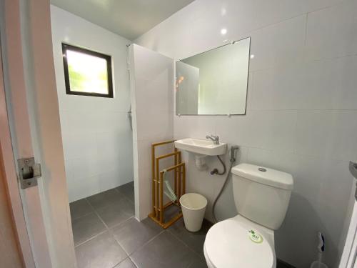 a bathroom with a toilet and a sink and a mirror at Hilltop Cabins (Calatagan, Batangas) in Calatagan