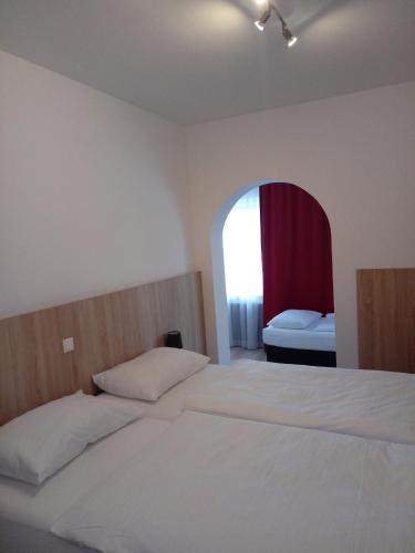 a bedroom with a bed and an arched window at Hotel Restaurant Schwartz in Neusiedl am Steinfelde