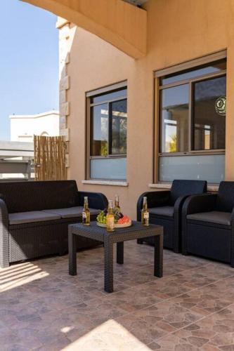 a patio with couches and a table with drinks on it at וילת נופש המלך שלמה in Wadi Keren