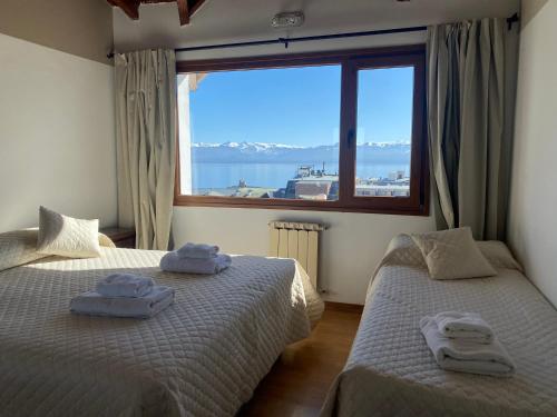 サン・カルロス・デ・バリローチェにあるHotel Garden Barilocheの大きな窓のある部屋にベッドが2つある