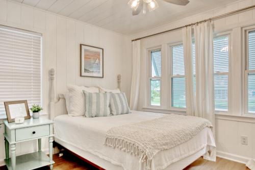 マートルビーチにあるLovely Beach Bungalowの白いベッドルーム(ベッド1台、窓付)