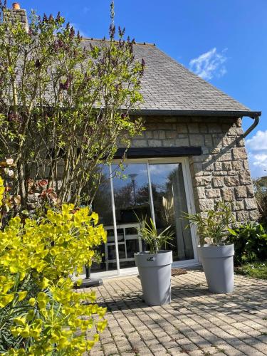 une maison avec 2 grands pots de plantes sur une terrasse dans l'établissement Appartement Le bonheur de vivre, à Saint-Coulomb