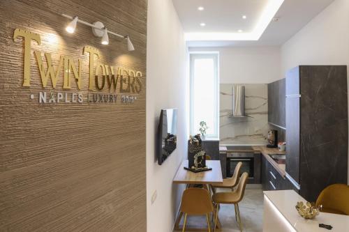 a kitchen and dining room with a sign on the wall at Twin Towers Naples Luxury in Naples