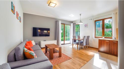 a living room with a couch and a table at Apartamenty Sun & Snow Villa Cztery Pory Roku in Jastrzębia Góra