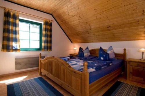 a bedroom with a wooden bed with blue sheets at TROLLHUS - Großes familienfreundliches Ferienhaus in Born