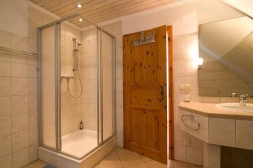 a bathroom with a shower and a tub and a sink at TROLLHUS - Großes familienfreundliches Ferienhaus in Born
