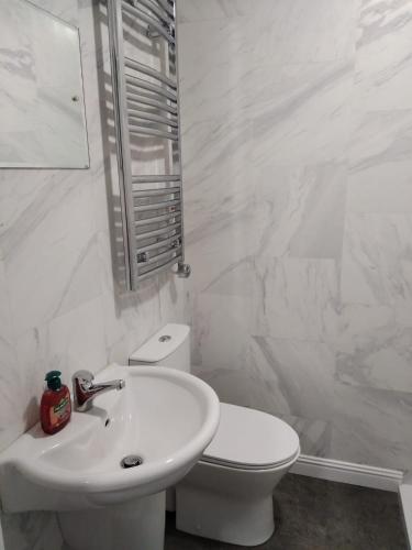 a white bathroom with a toilet and a sink at Rock House in Carrickmacross