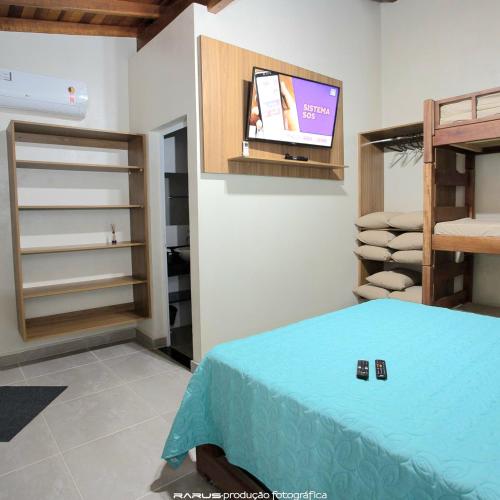a bedroom with a bed and a tv in a room at Lago e Lazer in São Roque