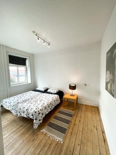 een slaapkamer met een bed en een houten vloer bij Finlandsgade 18 2th ID 047 in Esbjerg