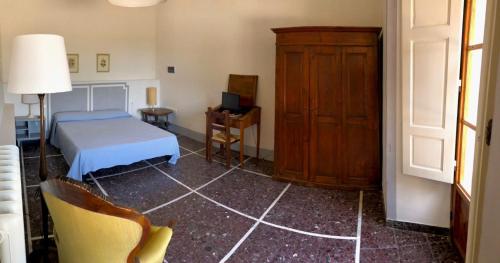 een slaapkamer met een bed, een kast en een stoel bij Il Salotto di Berentano in San Casciano in Val di Pesa