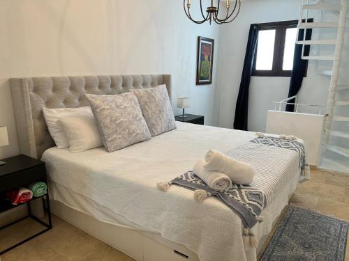 a bedroom with a large bed with white sheets and pillows at KASA Roof Top 6 1 bed 1 bath for 2 Guests AMAZING Views Old San Juan in San Juan