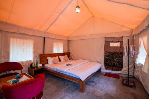 a bedroom with a bed in a tent at SAILYA CAMPING AND TREKKING in Saturang