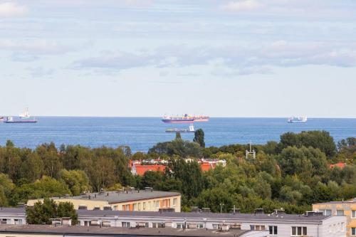 a view of the ocean with ships in the water at Seaview Apartment Gdańsk Przymorze by Renters in Gdańsk