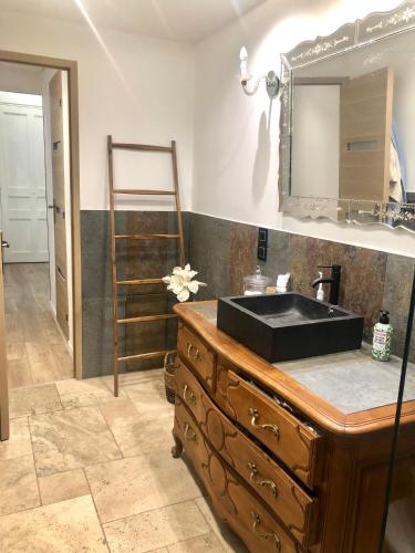 une salle de bain avec un lavabo noir et un miroir dans l'établissement Appartement zen avec patio et climatisation, en centre-ville, à Nice