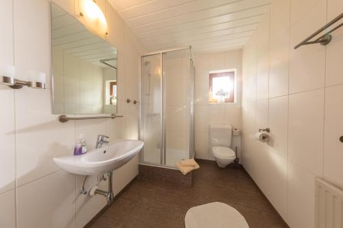 a bathroom with a sink and a shower and a toilet at T3 Pension Wald am Arlberg in Wald am Arlberg
