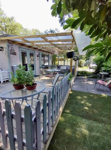 d'une terrasse avec des tables et des chaises et une clôture. dans l'établissement Isidaura, à Zutendaal