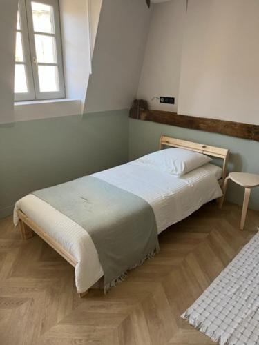 1 dormitorio con cama y ventana en LE CHAPITRE - Agréable maison de ville en Autun