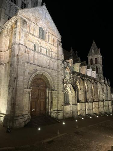 a large stone building with a large door at night at LE CHAPITRE - Agréable maison de ville in Autun