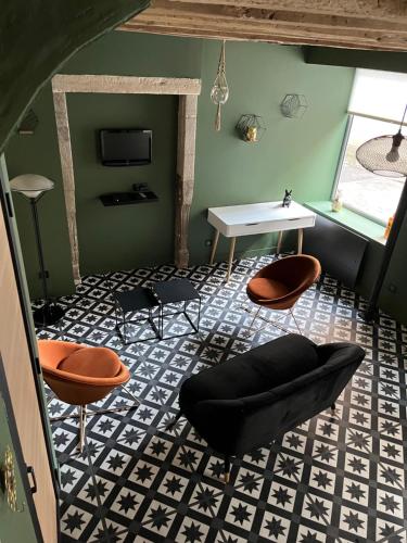 a living room with chairs and a table and a table at LE CHAPITRE - Agréable maison de ville in Autun