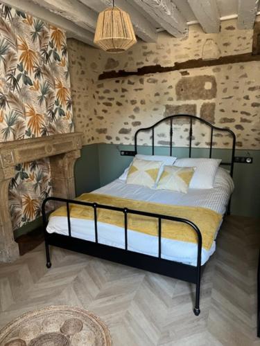 a bedroom with a bed with a black metal frame at LE CHAPITRE - Agréable maison de ville in Autun