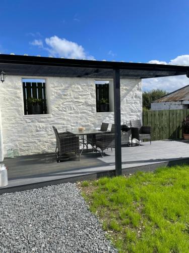 a patio with a table and chairs and a building at Cozy 2 bedroom cottage with log burner close to Loch Ken in New Galloway