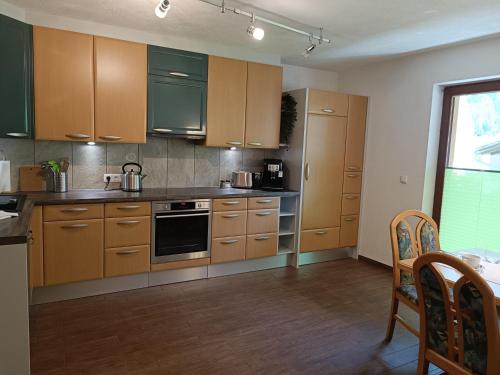 a kitchen with wooden cabinets and a stove top oven at Ferienwohnung Sonja in Bach