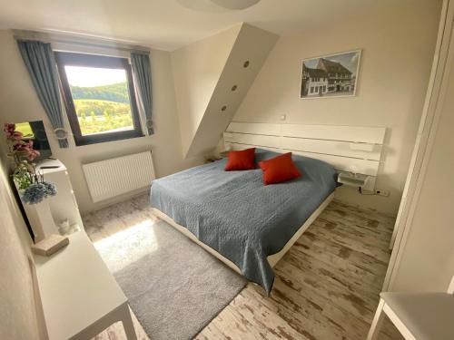 a bedroom with a bed with two red pillows at Ferienhaus Auenblick DELUXE in Eisenach