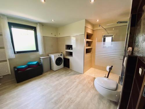 a bathroom with a sink and a washing machine at Ferienhaus Auenblick DELUXE in Eisenach