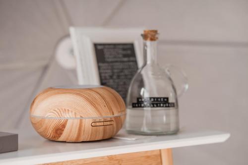 a wooden bowl and a bottle on a shelf at Maja Luxury Glamping Suites in Mäntyharju