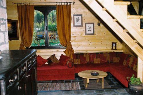 a living room with a red couch and a window at Zeleni Čardaci etno apartmani in Kaludjerske Bare