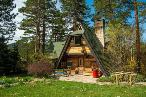 a log cabin with a green roof at Zeleni Čardaci etno apartmani in Kaludjerske Bare