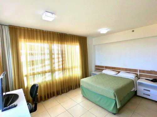 um quarto com uma cama, uma secretária e uma janela em Saint Moritz com vista espetacular de Brasilia em Brasília