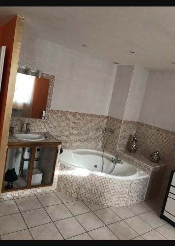 een badkamer met een bad en een wastafel bij Maison Sainte Marthe in Marseille