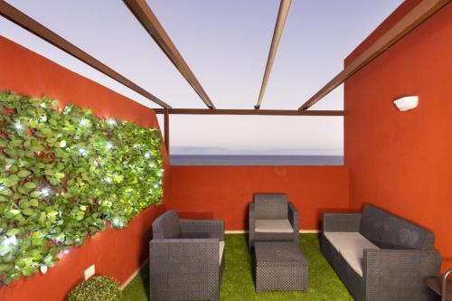 プエルティト・デ・グイマルにあるHome2Book Sea Front Duplex Terrace Poolの椅子2脚と植物1本付きの部屋