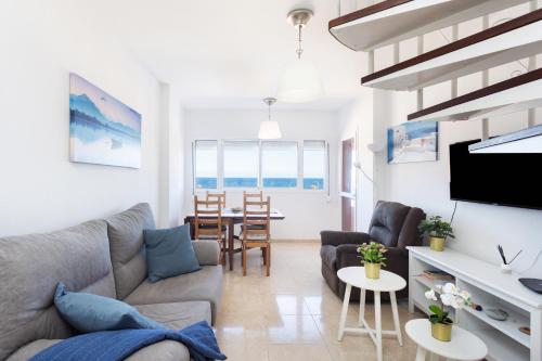 sala de estar con sofá y mesa en Home2Book Sea Front Duplex Terrace Pool, en Puertito de Güímar
