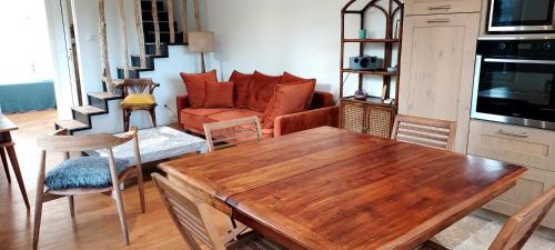 un salon avec une table en bois et un canapé dans l'établissement Le Bois Flotté - Maison au cœur de la Loire entre ville et nature, à Saumur