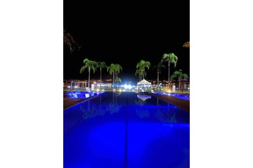 a swimming pool at night with blue lights at Brisas do Lago - Apartamento 7 in Brasilia
