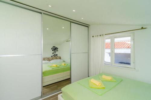 a white bedroom with a bed and a window at Sunny rooms in Dubrovnik