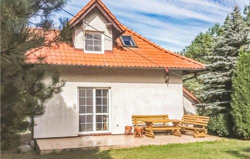 a white house with a bench and a picnic table at Three-Bedroom Holiday Home In Szteklin in Szteklin