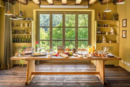 uma mesa com comida numa sala com uma janela em Country House La Bursch em Campiglia Cervo