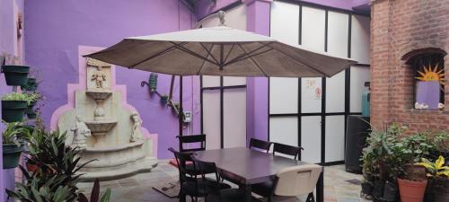 un edificio púrpura con mesa y sombrilla en Posada don Matias, en Oaxaca City