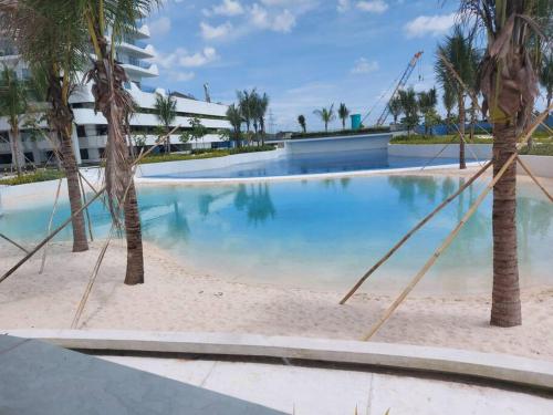 uma piscina com palmeiras num resort em Skycourt Suites at Azure North Pampanga Condominium em San Fernando