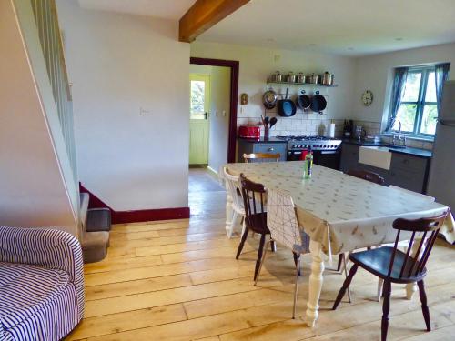 High Ground Cottage, Eskdale في إسكاديل: مطبخ مع طاولة وكراسي في غرفة