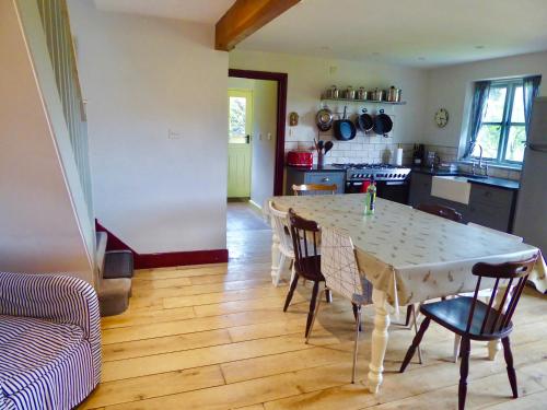 a kitchen with a table and chairs in a room at High Ground Cottage, Eskdale in Eskdale